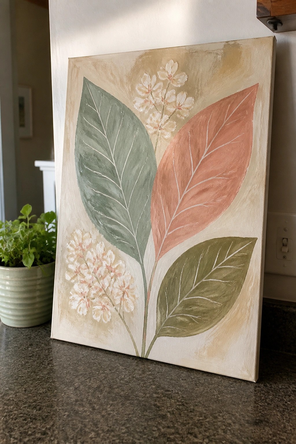 Botanical canvas art with sage green, coral, and olive leaves plus white flowers