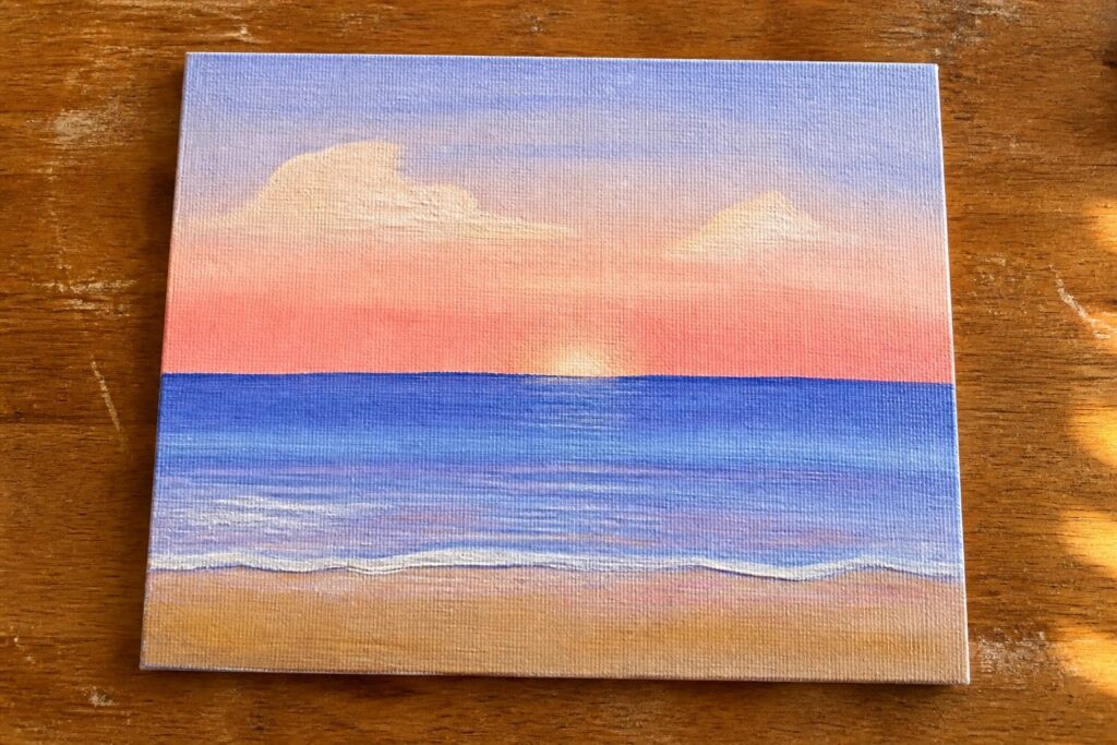Canvas painting of beach sunset with purple-pink sky, setting sun, and blue waves.