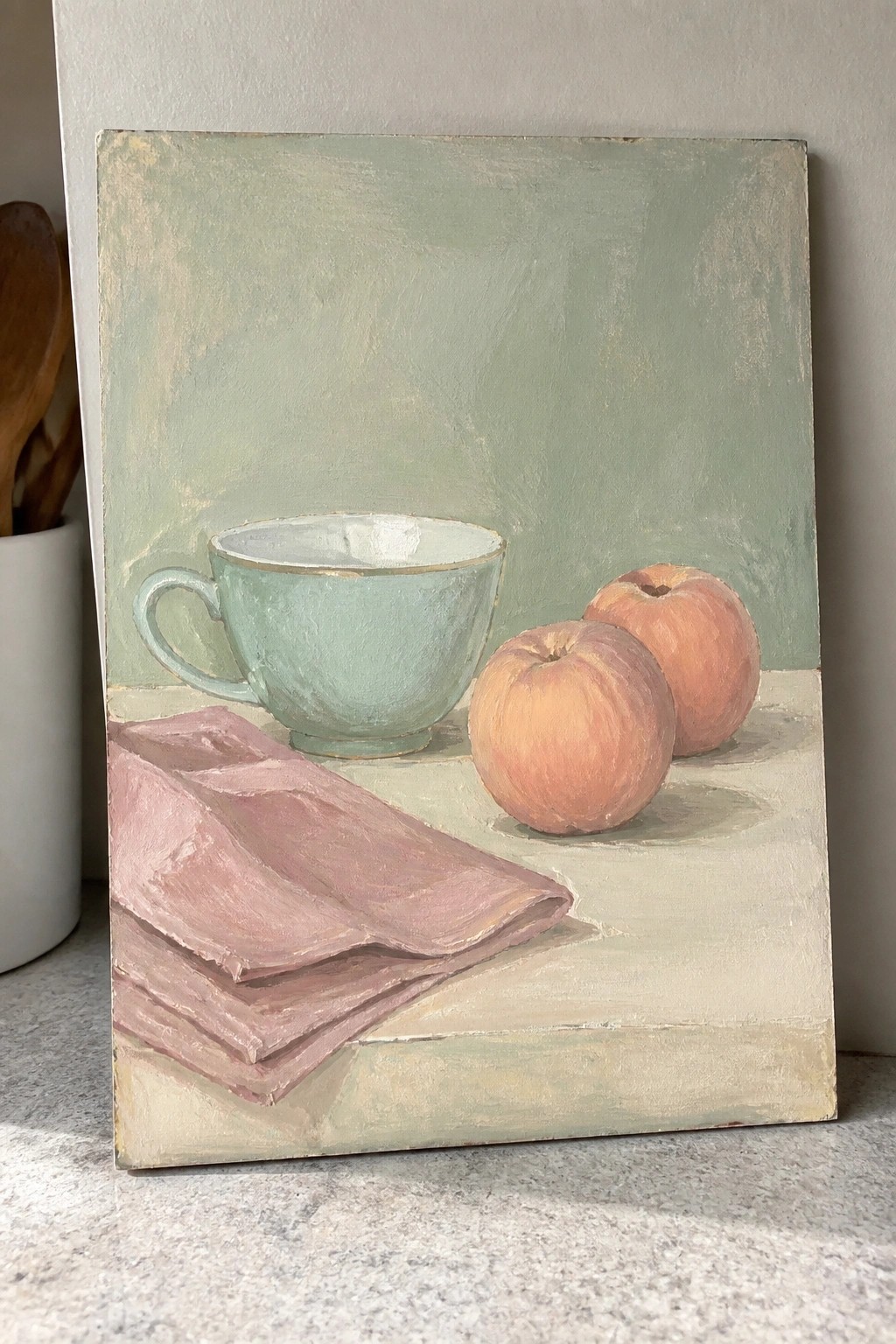 Still life painting of mint cup, two peaches, and pink draped cloth on table.