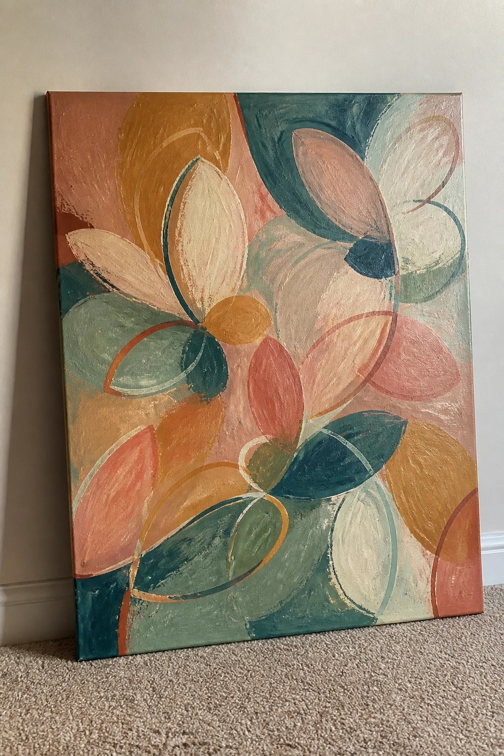 Abstract painting with overlapping floral petals in coral teal orange peach and cream against wall