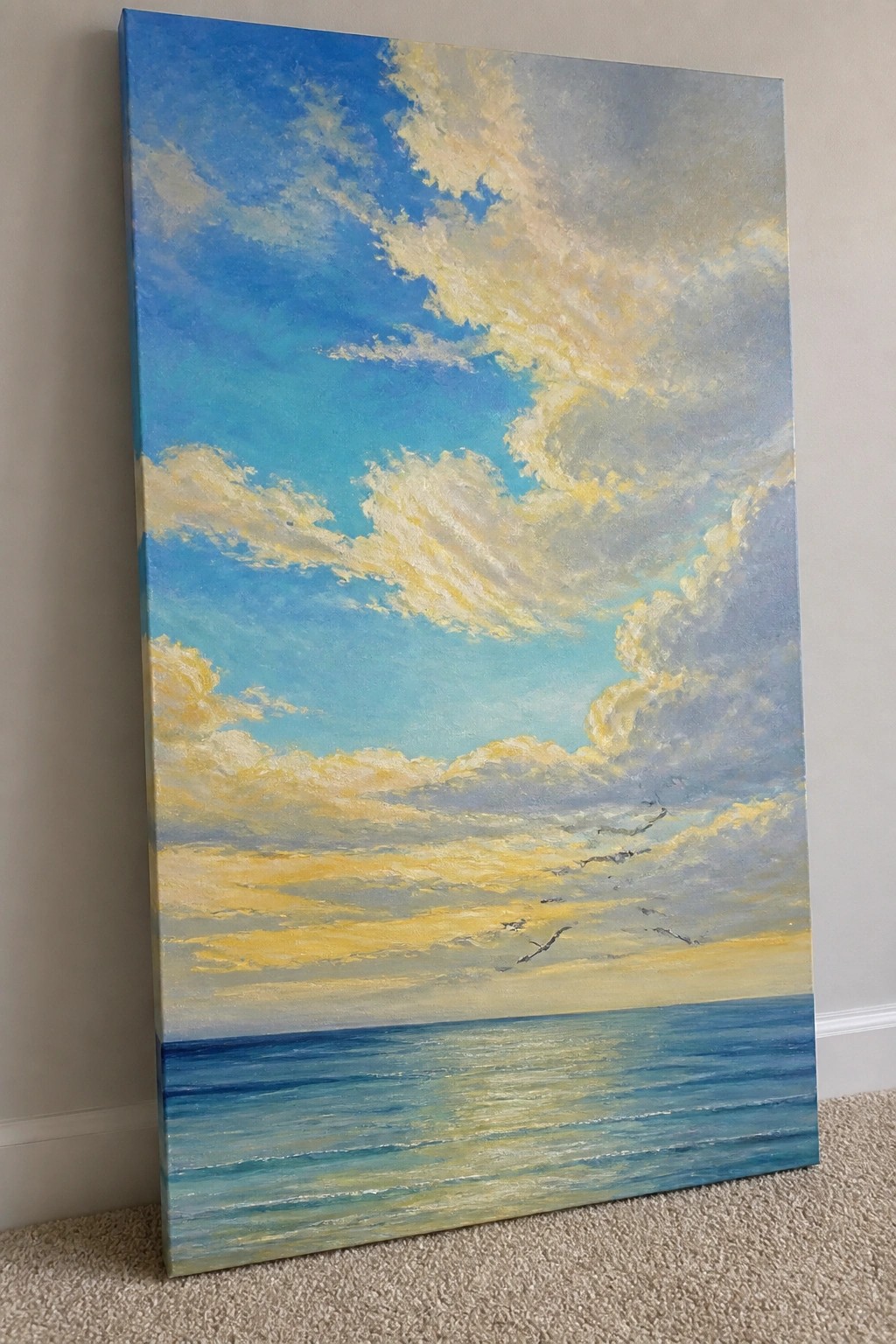 Oil painting of a seascape with golden clouds over blue ocean and birds.