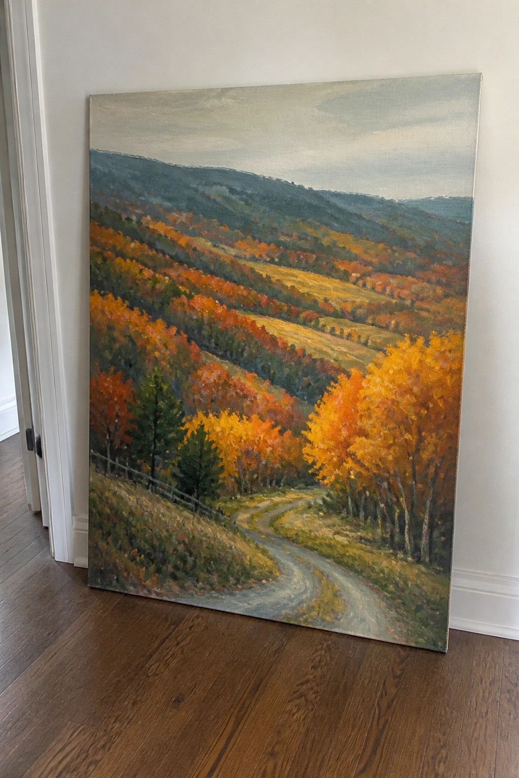 Large autumn landscape painting with winding road through vibrant hills against wall
