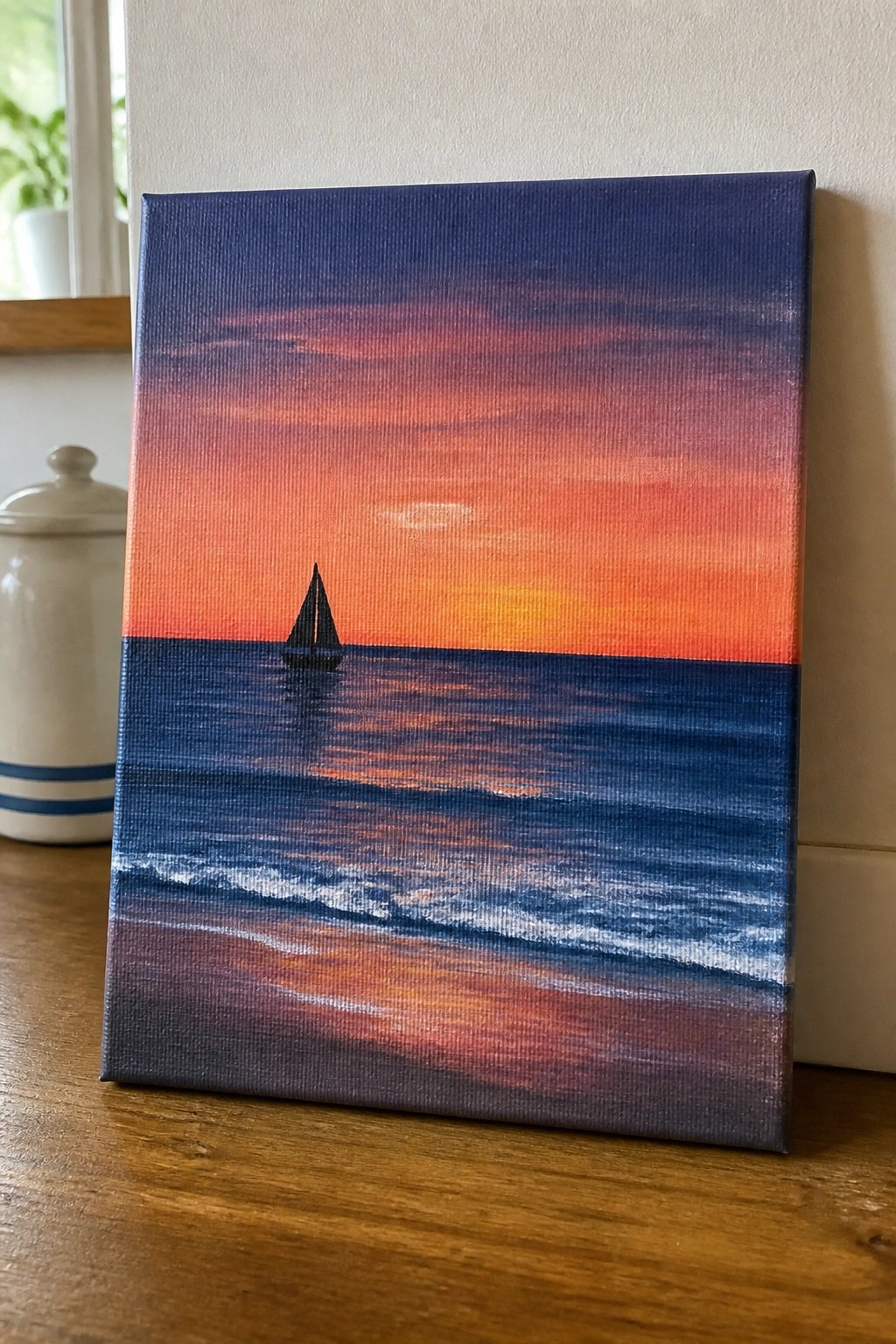 Seascape painting of sailboat on ocean under vibrant orange-pink sunset sky with waves