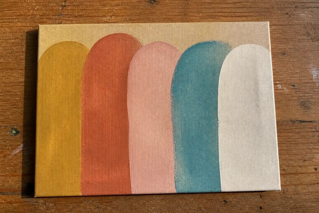 Abstract painting on canvas with vertical rounded arches in yellow, orange, red, pink, teal and white.