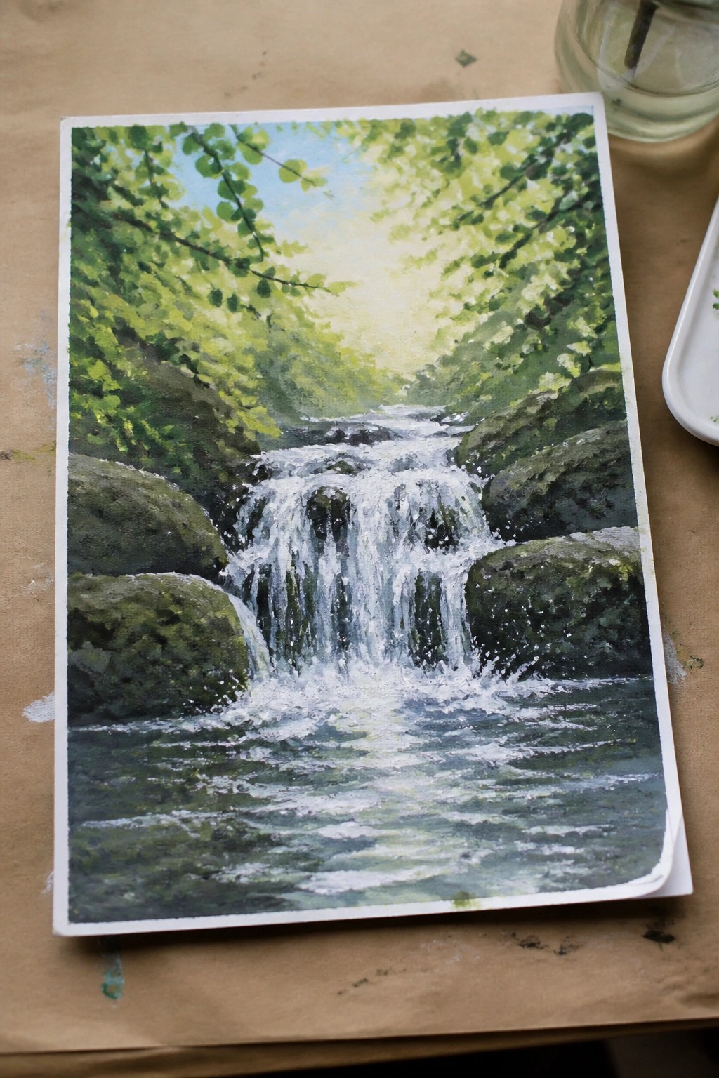 Watercolor painting of cascading waterfall over rocks amid lush green forest foliage.