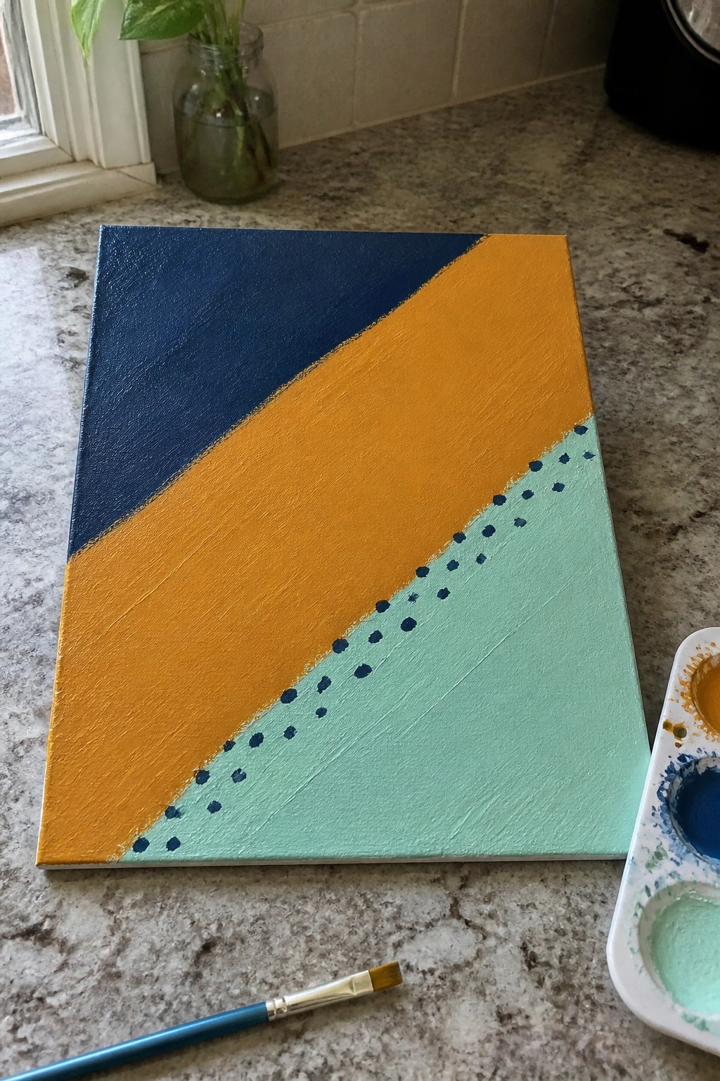 Canvas with blue, orange, and mint green sections divided by dotted line on counter