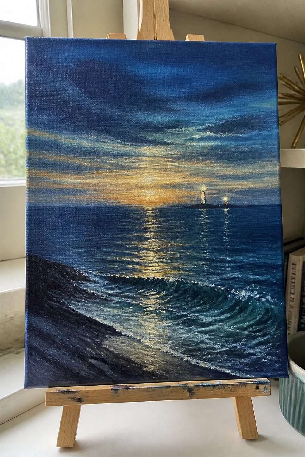 Realistic painting on easel of crashing ocean waves with golden sunset reflection and distant lights