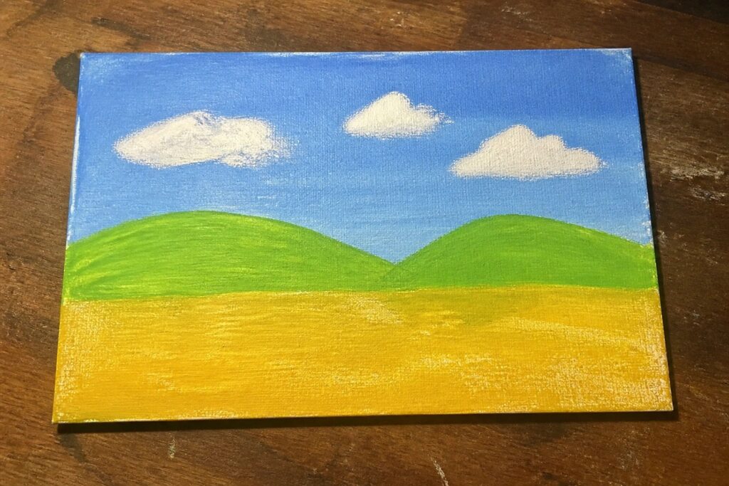 Painting of blue sky with white clouds above green hills and yellow field on wood