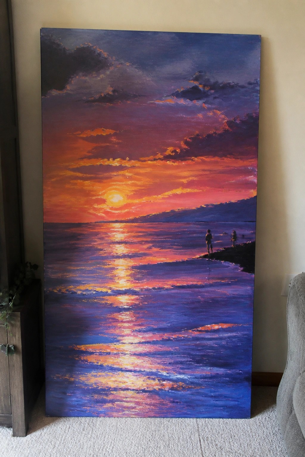 Vivid painting of orange-purple sunset reflecting on ocean with two figures on shore