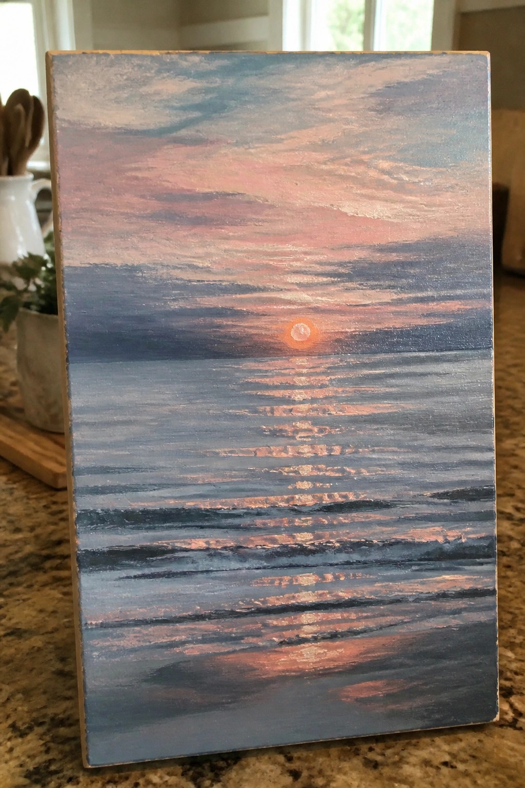 Oil painting on wood of sunset over ocean with orange sun and pink-blue reflections