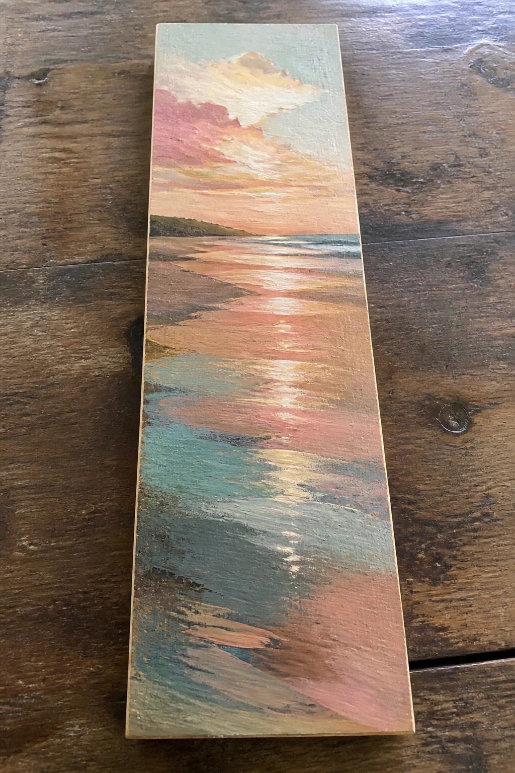 Vertical painting of vibrant sunset over beach with pink clouds and shimmering water reflections