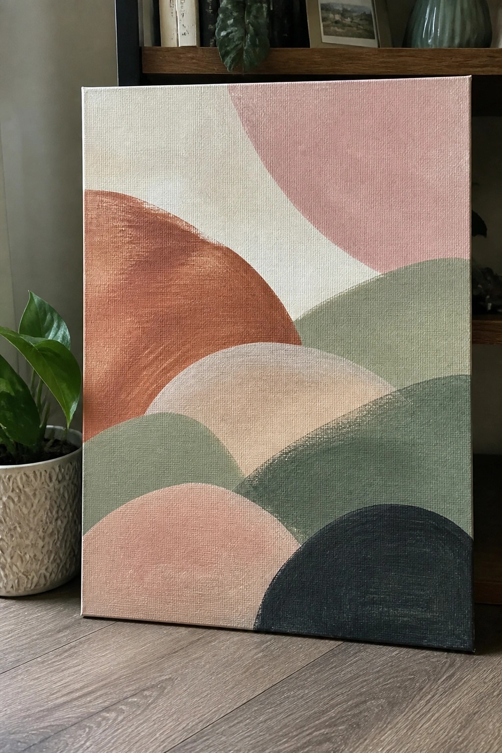 Abstract canvas with overlapping curved shapes in pink, terracotta, green, beige, and black.