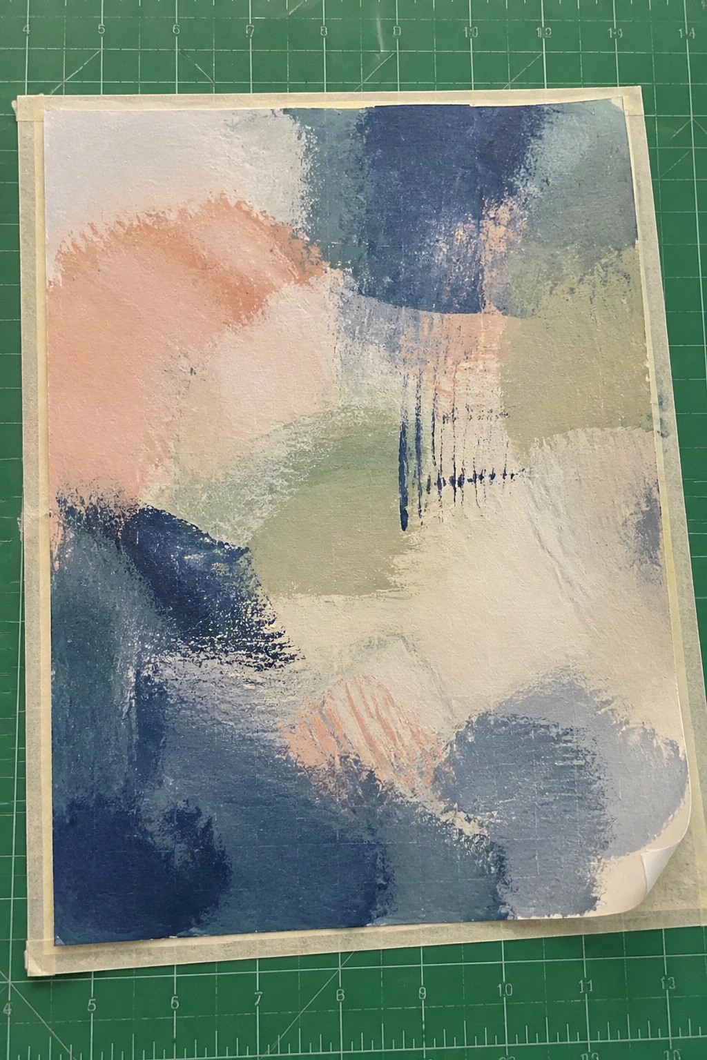 Abstract painting with peach, blue, green brushstrokes on white paper taped to green mat