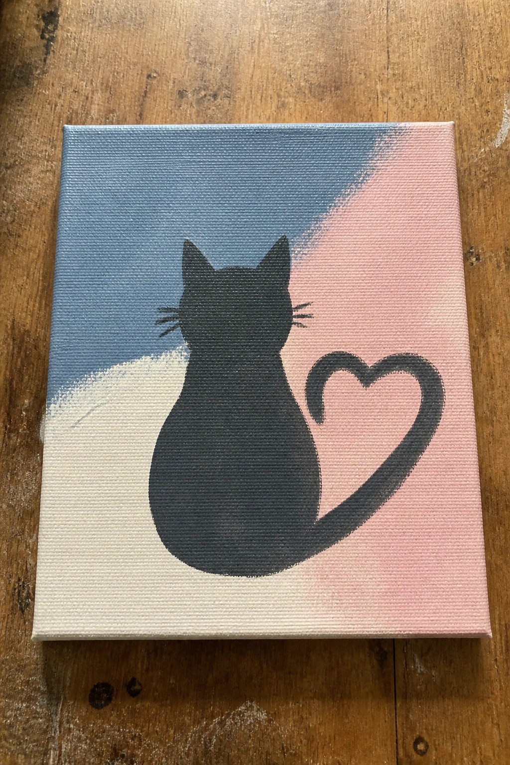Black cat silhouette with heart-shaped tail on split blue pink canvas painting