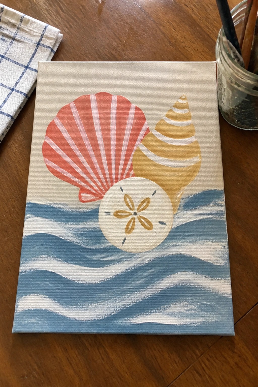 Painting of red striped shell, yellow conch, sand dollar over blue waves