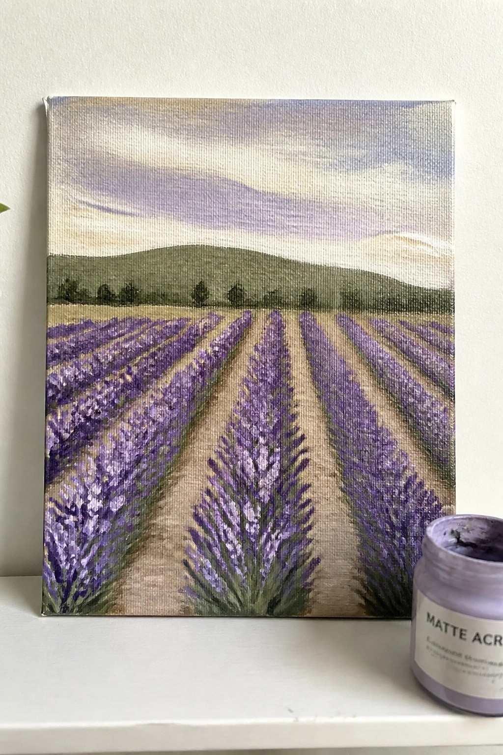 Lavender field acrylic painting on canvas beside matte purple paint jar