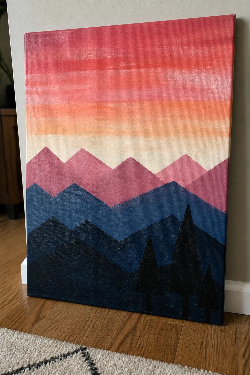 Geometric mountain landscape painting with gradient red-pink sky, layered peaks, and black pine trees