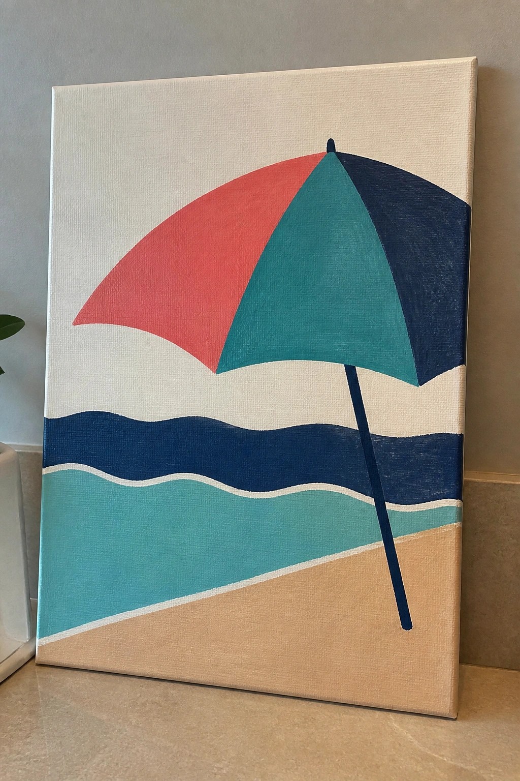 Colorful beach umbrella painting with red teal navy sections over wavy ocean and sand