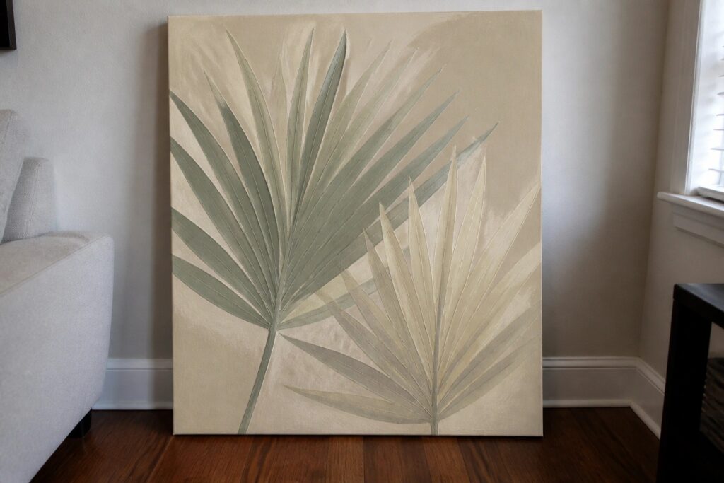 An acrylic painting of several large palm leaves in green and beige tones on a textured beige canvas.