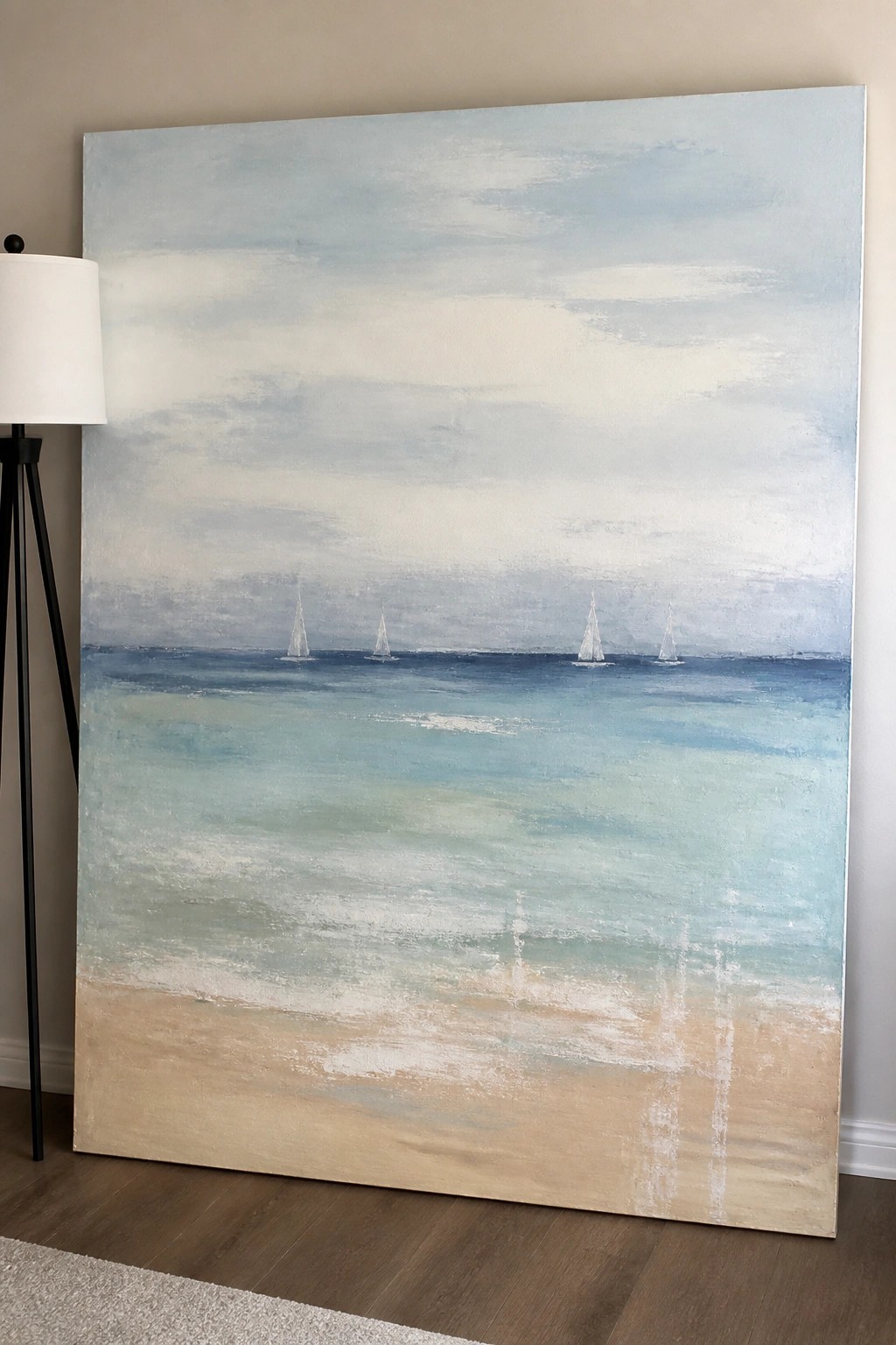 Large abstract seascape painting with sailboats on blue ocean beside floor lamp