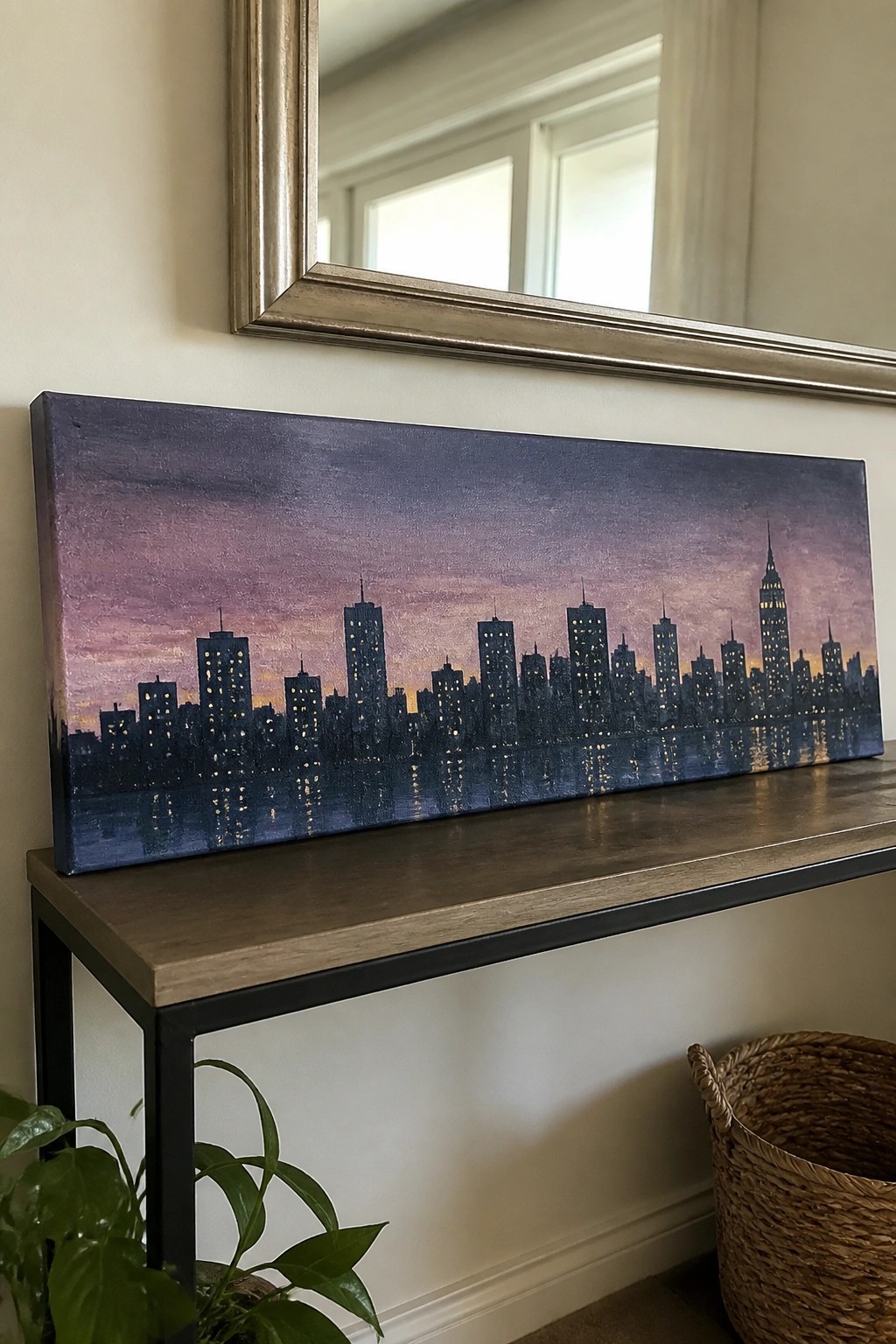 City skyline painting with glowing windows and reflections on wooden console table