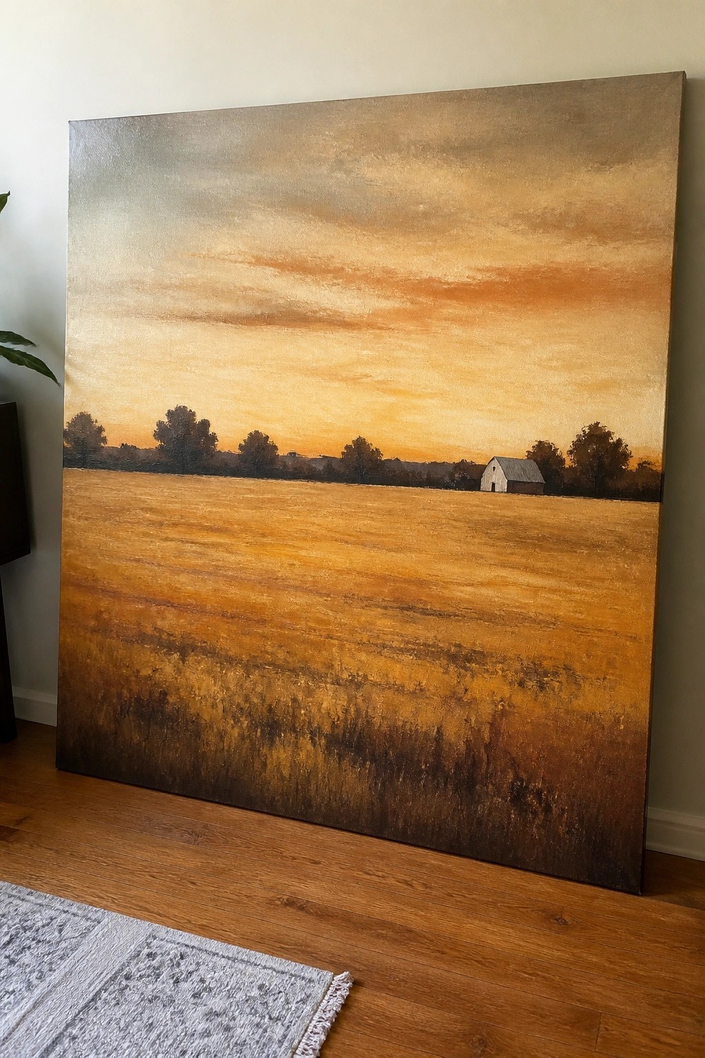 Large landscape painting of golden field with distant barn at sunset