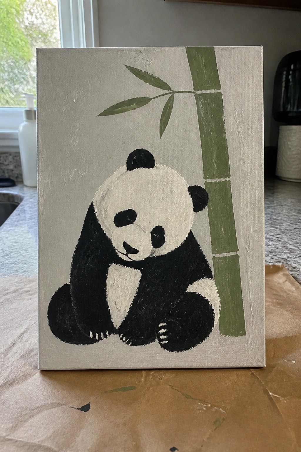 Acrylic painting of black-and-white panda sitting beside green bamboo on beige canvas.