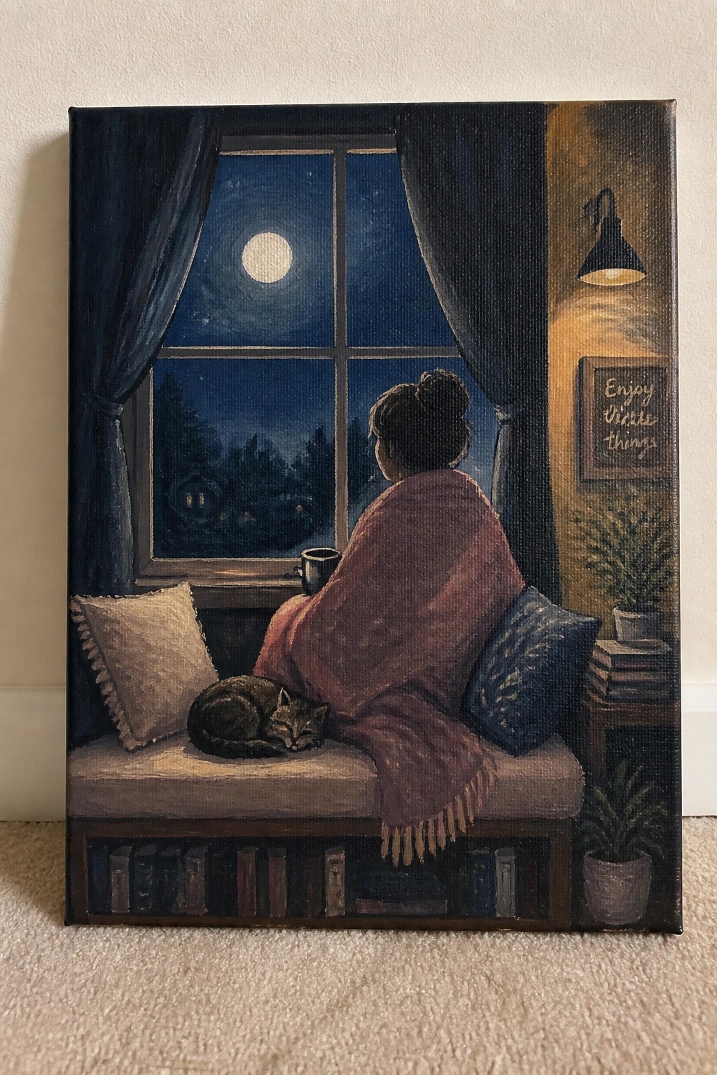 Woman in red blanket sits by moonlit window with sleeping cat on window seat.