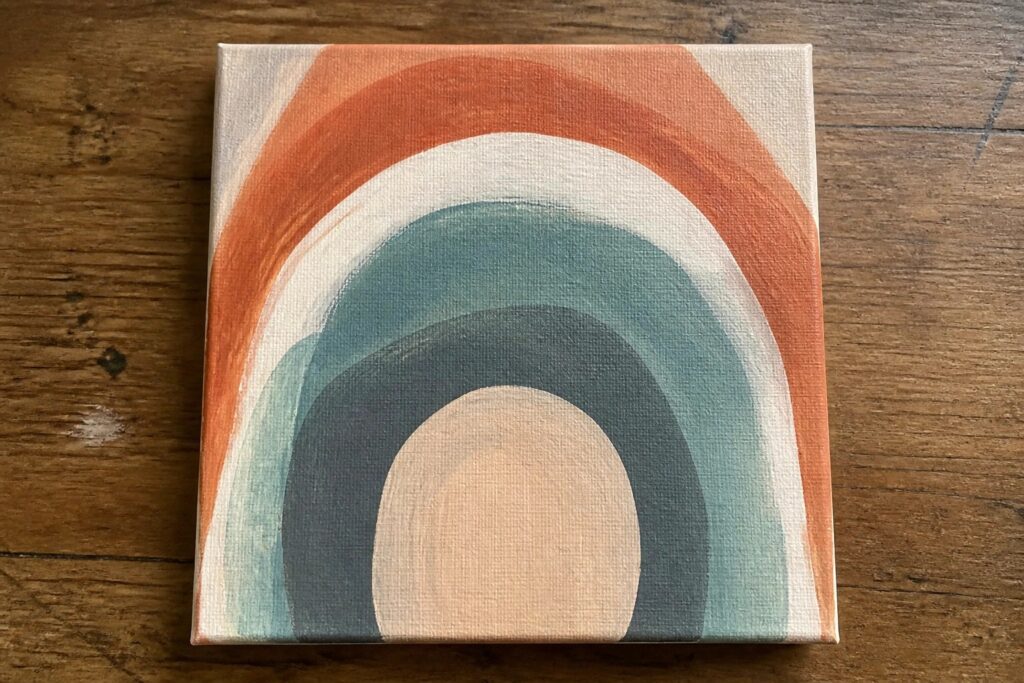 Abstract painting on canvas with curved bands in coral, teal, navy and white on wood