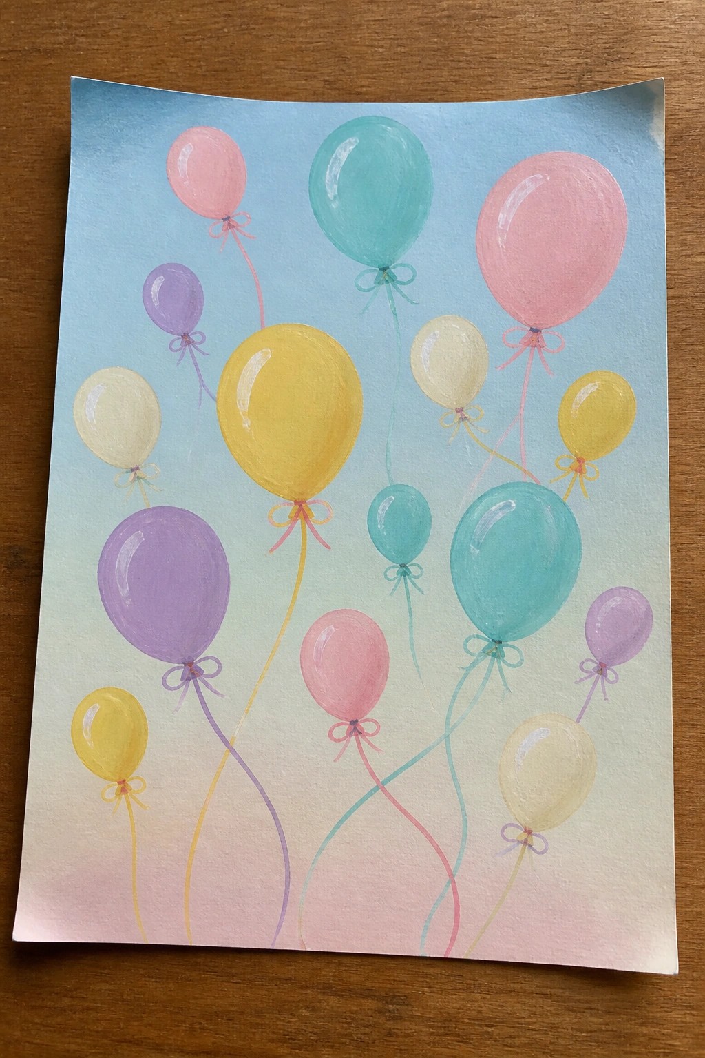 Colorful balloons in pink, yellow, teal, and purple with curly ribbons on gradient sky