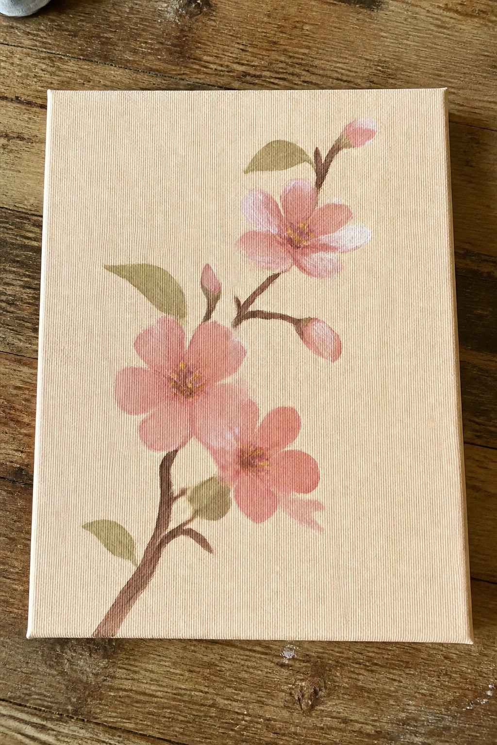 Pink cherry blossoms on branch with buds and leaves on canvas.