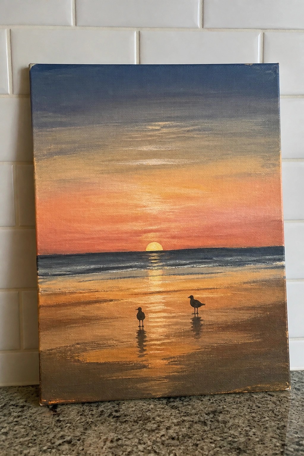 Sunset painting of orange sky over ocean with two silhouetted birds on wet sand