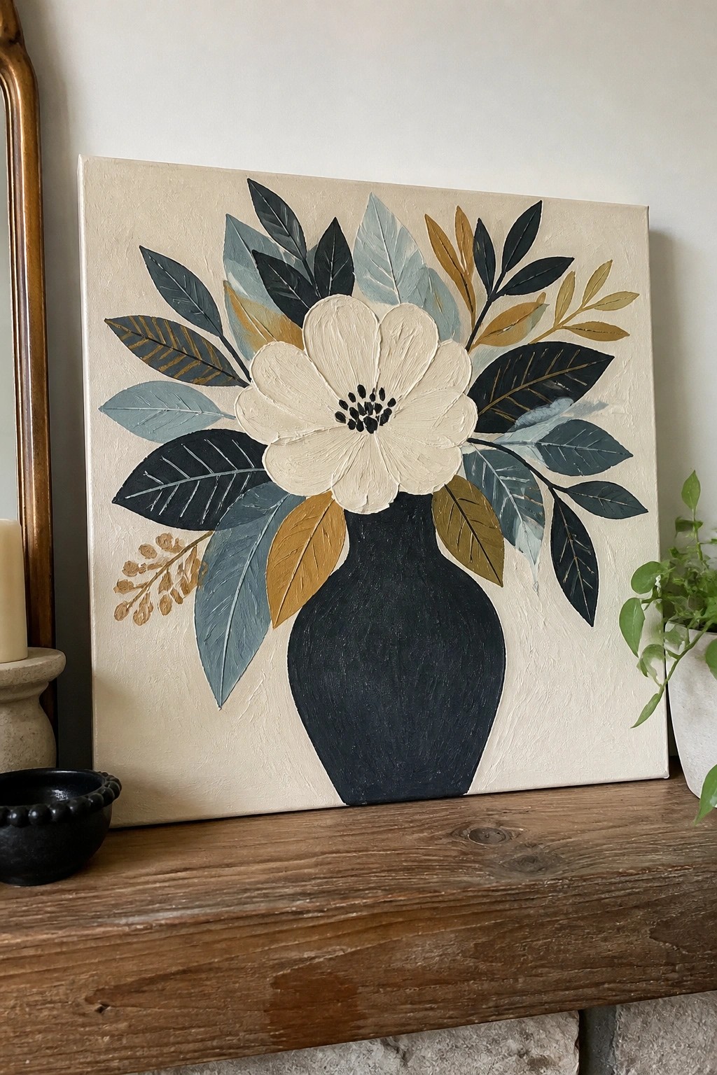 Canvas painting of black vase with white flower and teal gold leaves on wood shelf