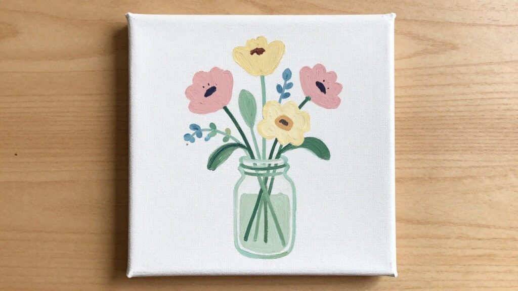 Three pink flowers with yellow centers in a blue glass jar on canvas.