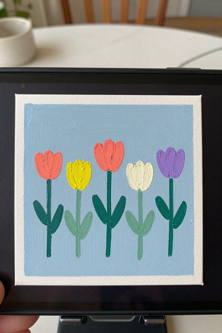 A small canvas showing five colorful tulips with green stems and leaves on a light blue background.
