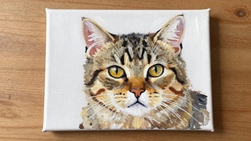 Realistic tabby cat portrait painting with yellow eyes on white canvas over wood