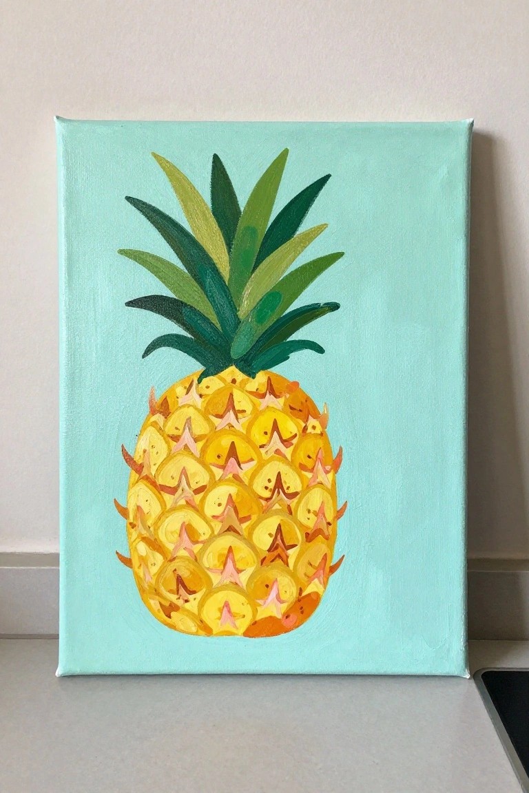 Yellow pineapple with green leaves painted on light blue canvas against white wall.