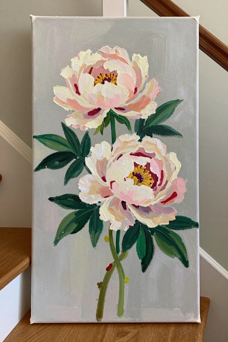 Two peonies with pink-white petals, yellow centers, and green leaves on gray canvas.