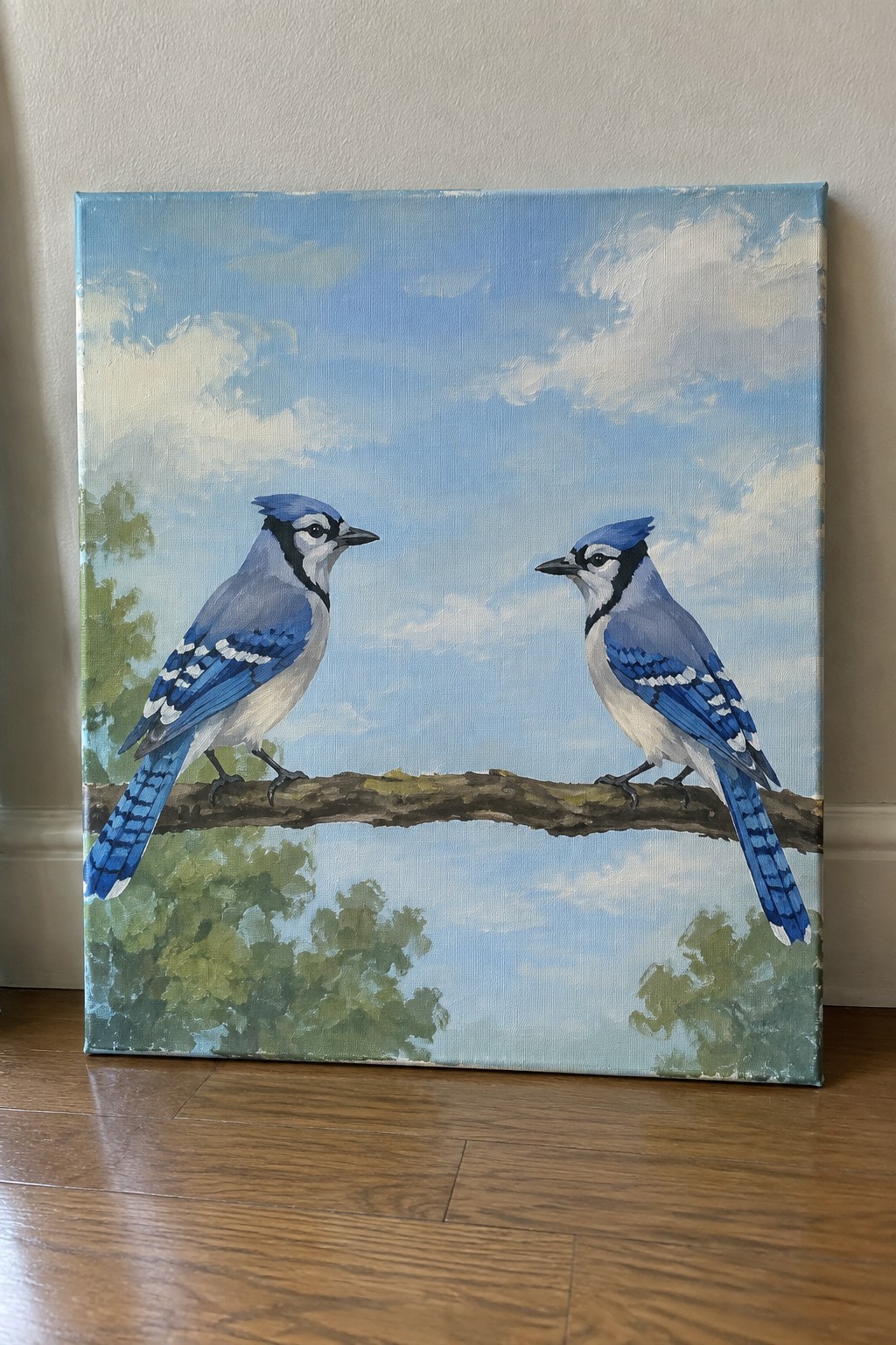 Two blue jays face each other on a branch beneath a cloudy blue sky in a painting.