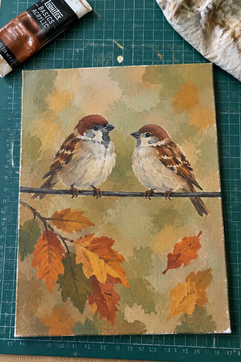 Two sparrows perch on a branch with orange autumn leaves in an acrylic painting