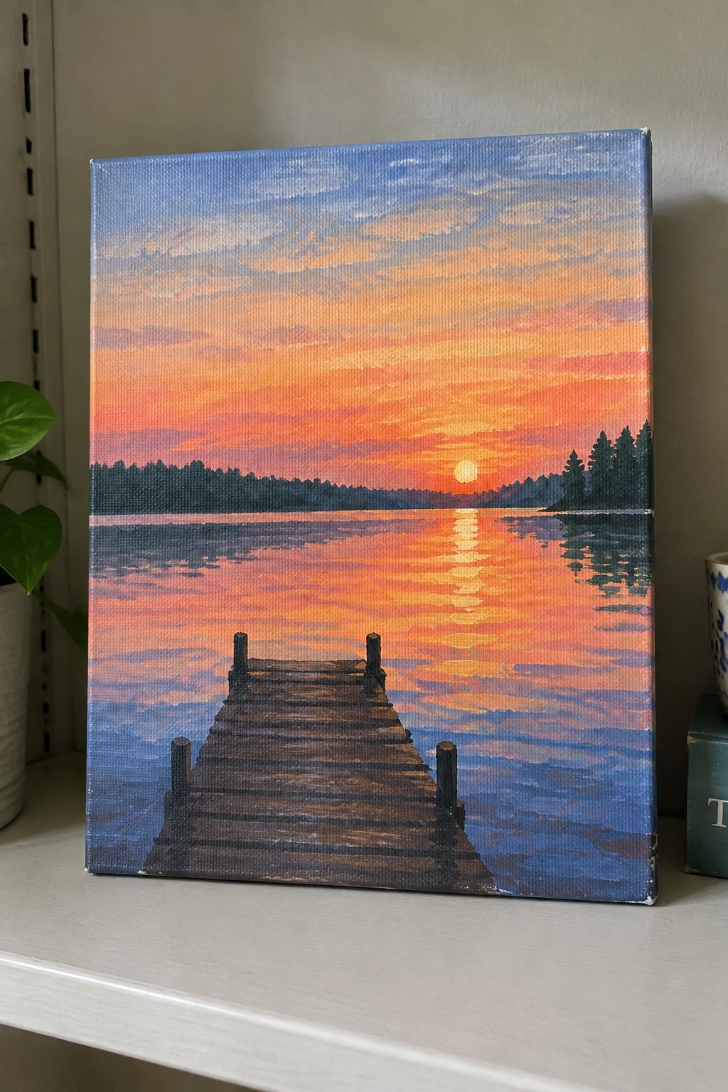 Painting of wooden dock on lake under vibrant orange sunset with reflections.