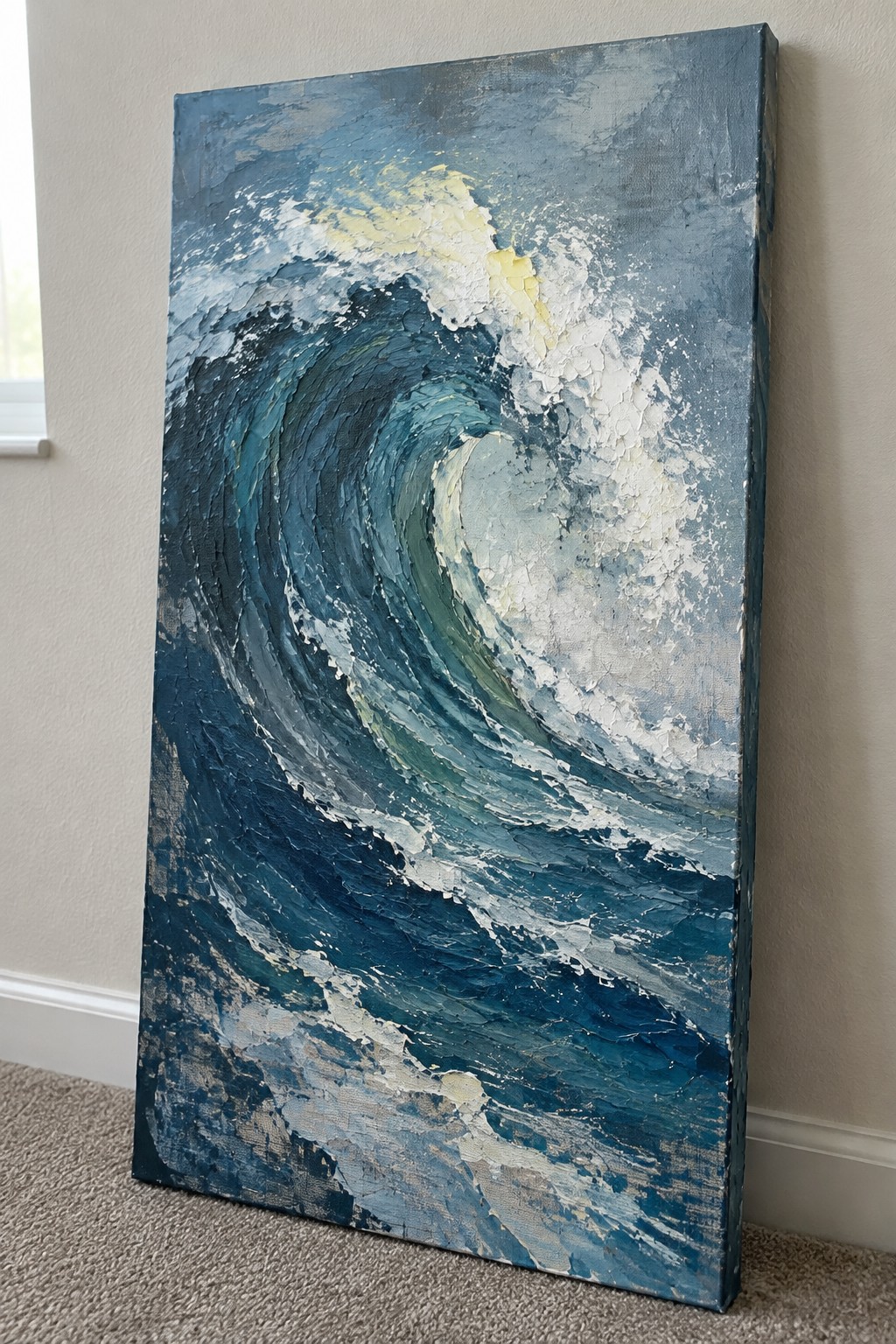 Thickly textured painting of a swirling blue ocean wave on canvas leaning indoors