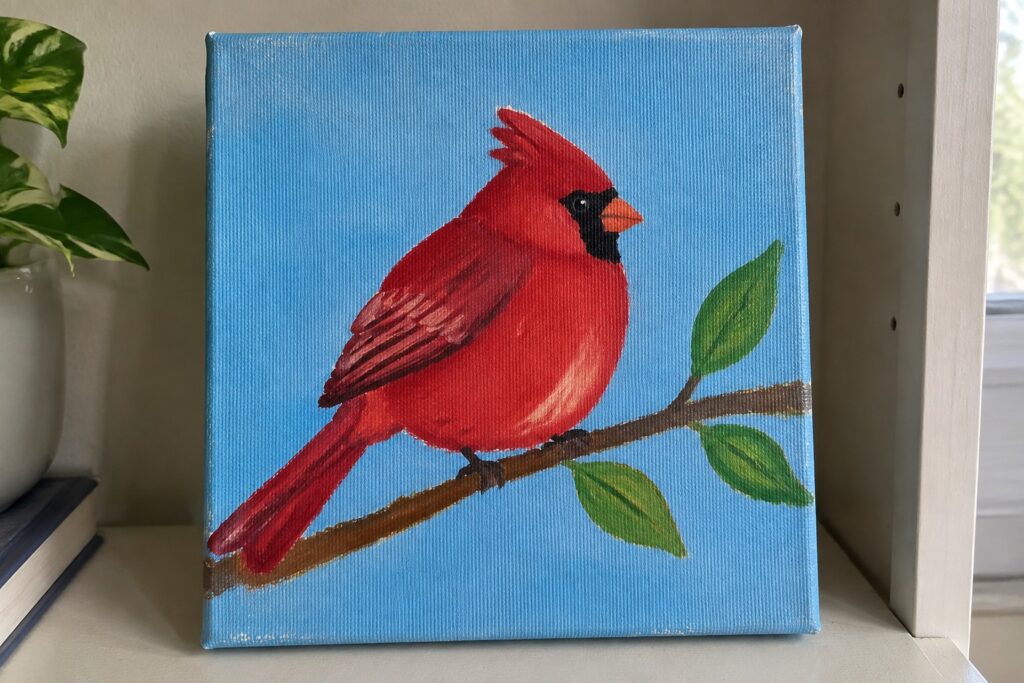17 Vibrant Red Bird Acrylic Paintings Featuring Branch Perches Red cardinal with crest on branch with green leaves against blue canvas background