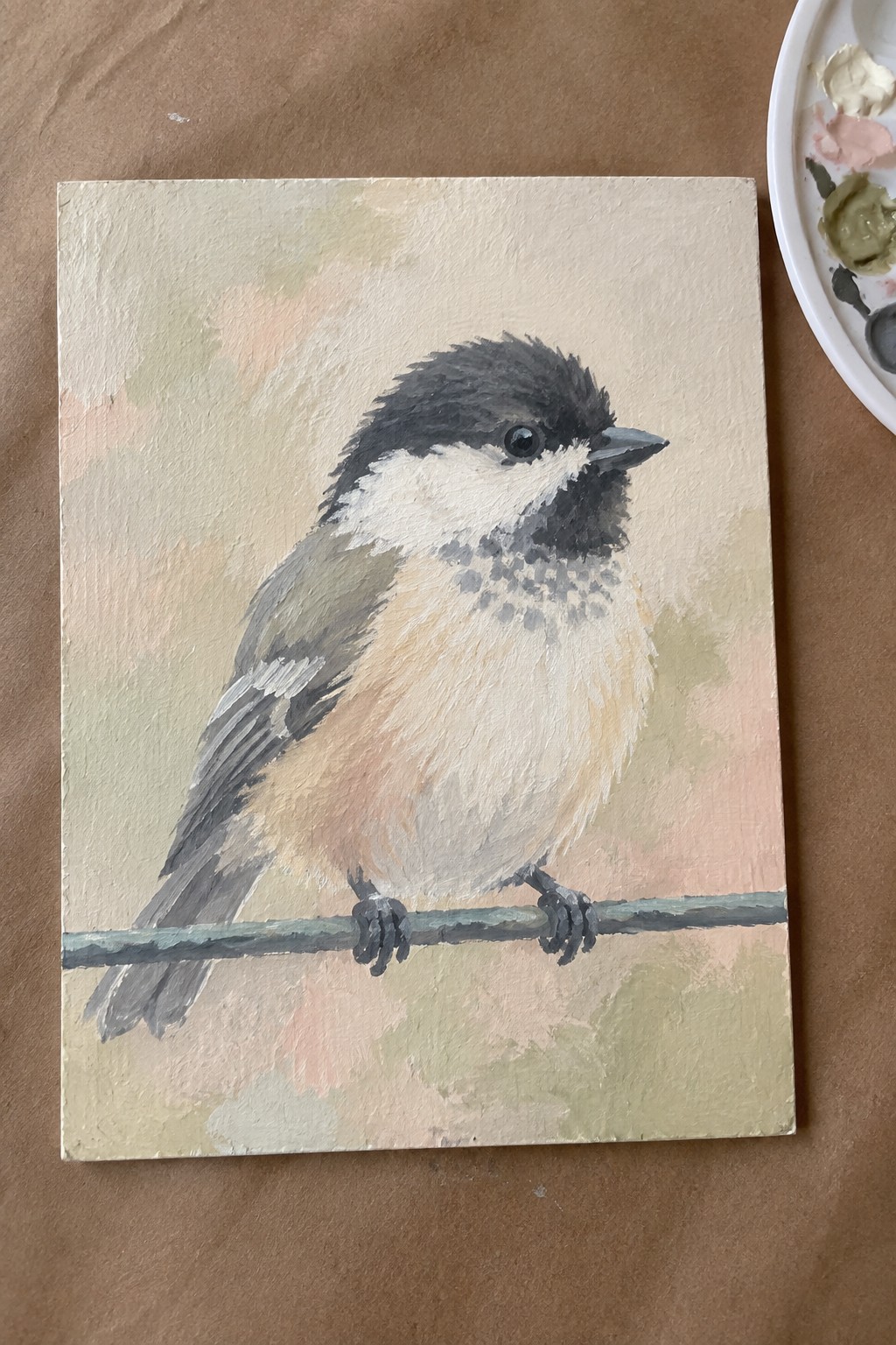 Painting of chickadee with black cap and white cheeks perched on branch