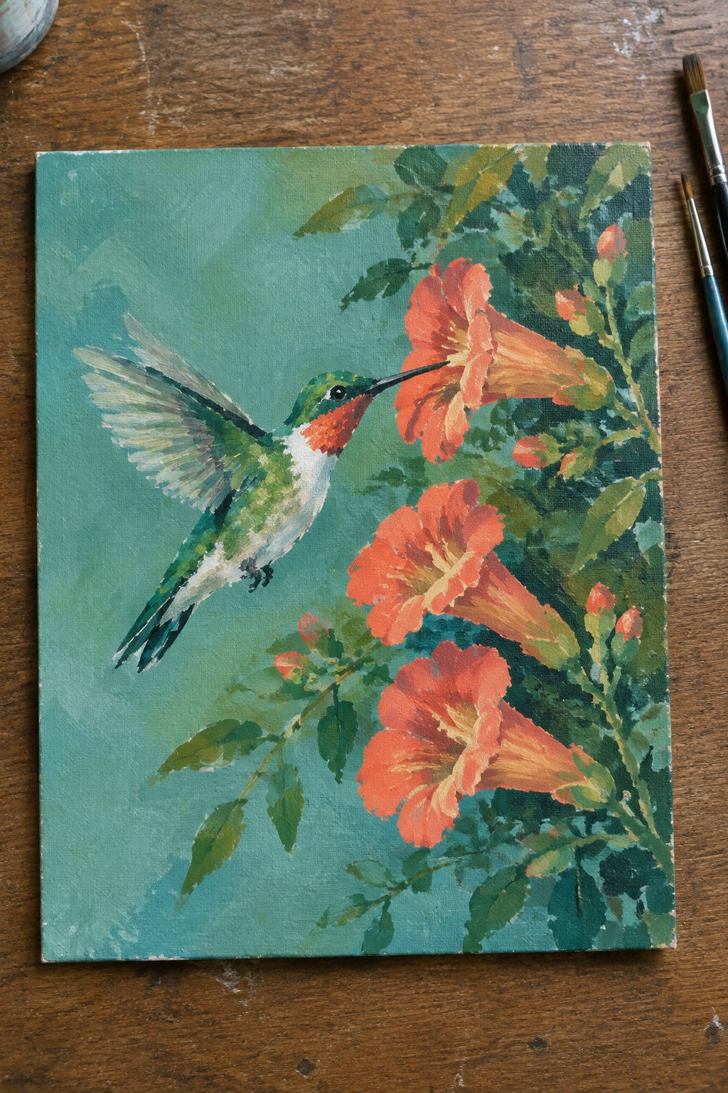 Vibrant painting of a hummingbird hovering near orange flowers on a teal canvas.