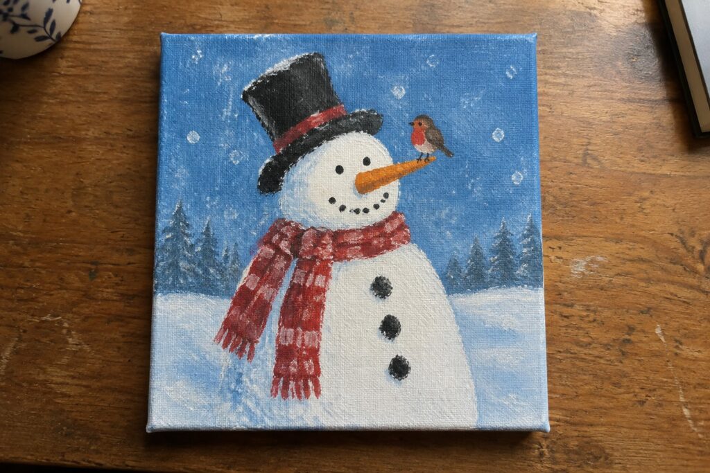 Snowman in black top hat and red plaid scarf with robin on carrot nose