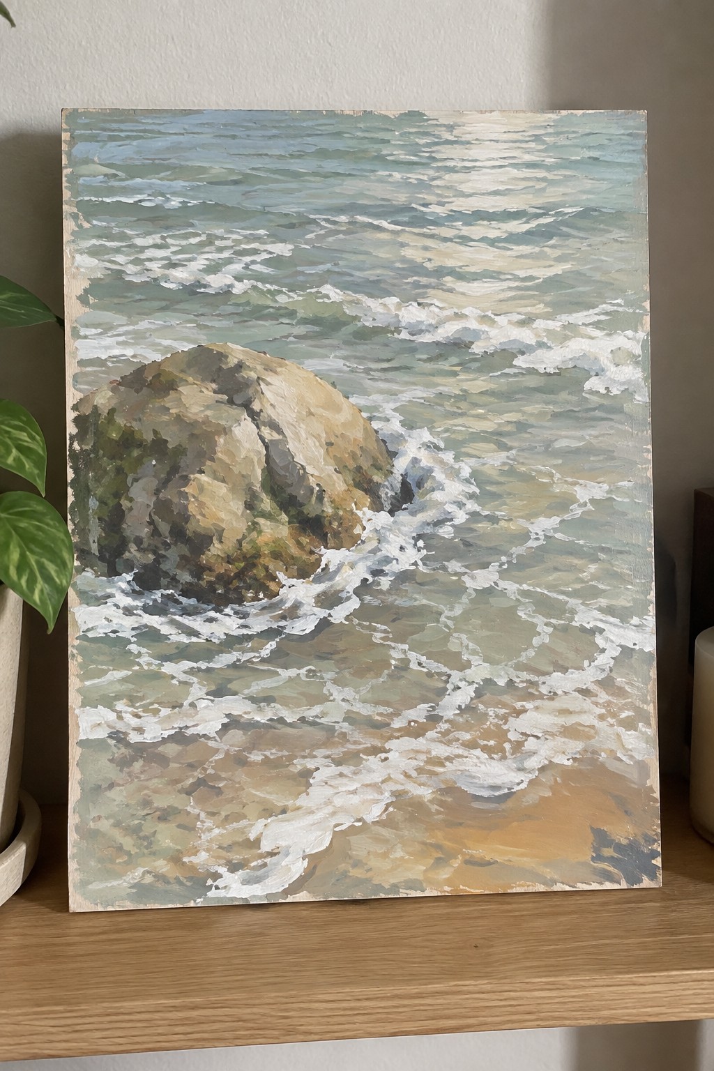 Painting of turquoise waves foaming around a large rock on sandy shore