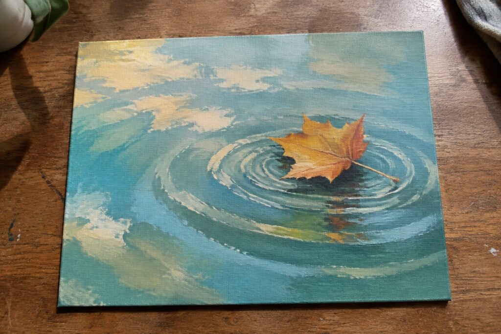 Orange maple leaf floating on rippled blue-green water under a cloudy sky