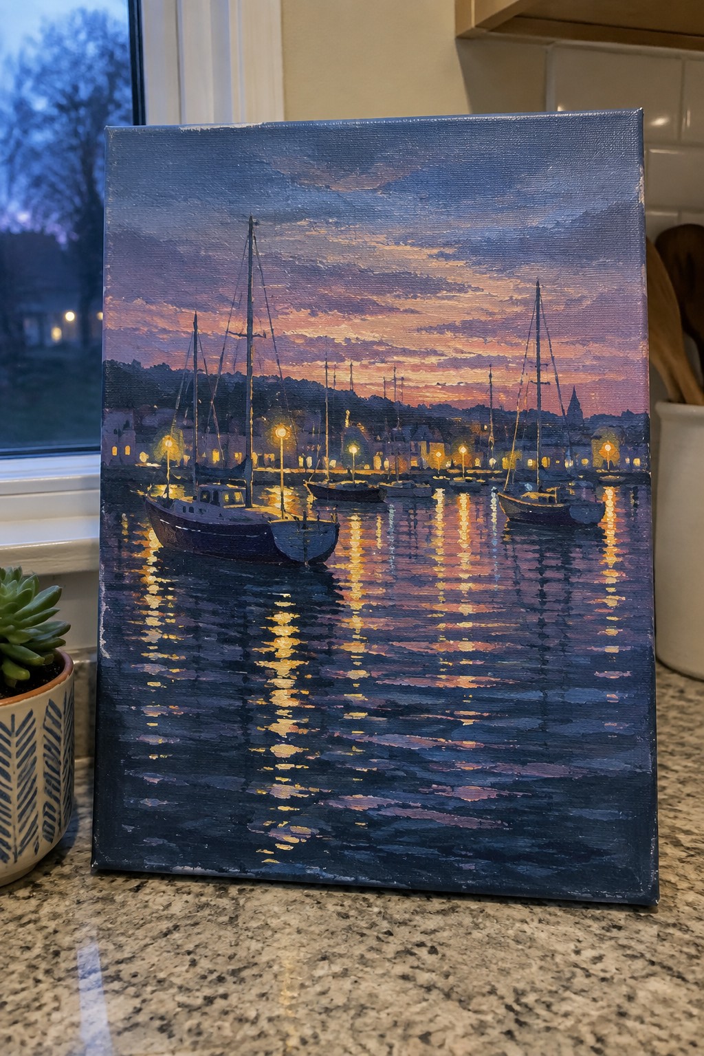 Harbor sunset painting with sailboats, glowing lights, and reflections on calm water