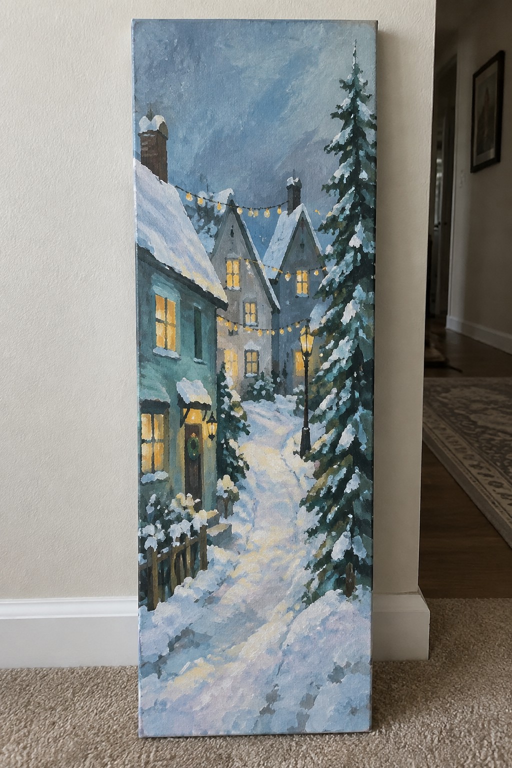 Snowy village path at night with glowing windows, string lights, and pine trees.